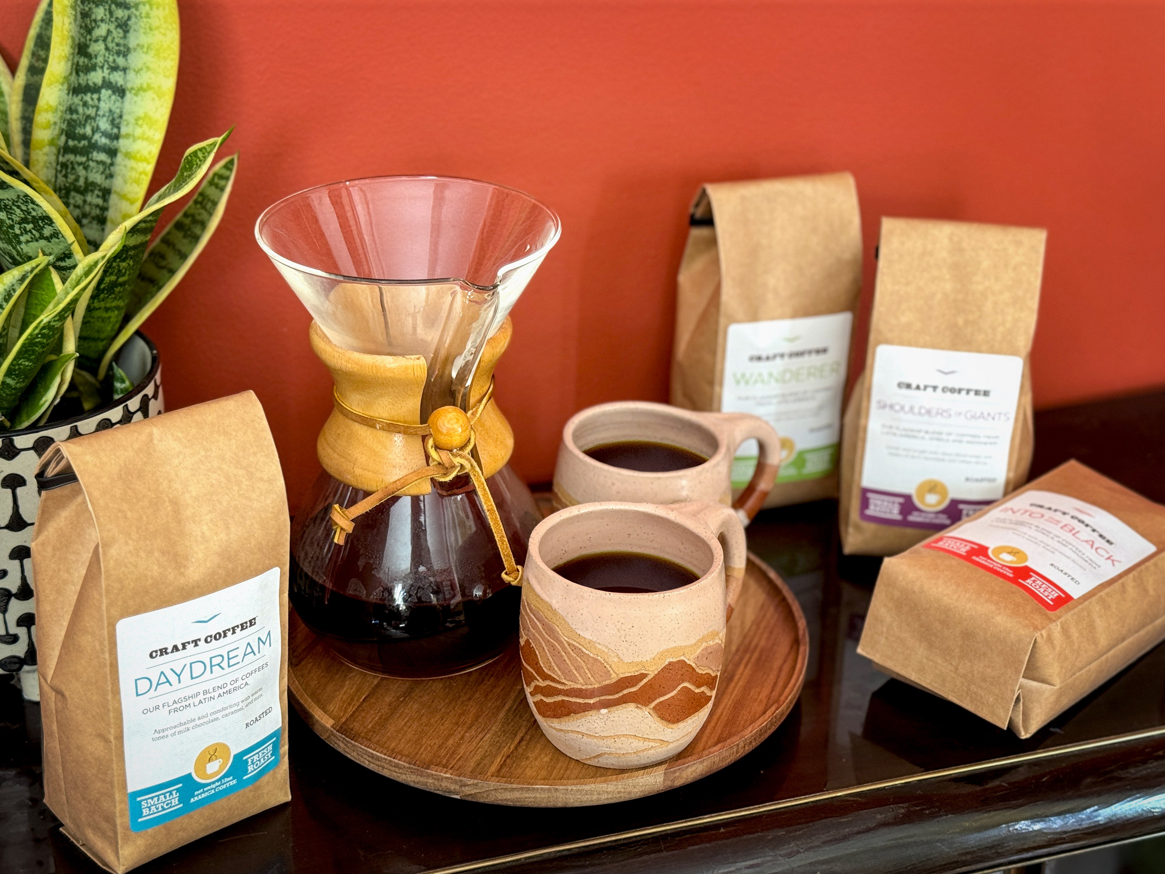 12oz bags of Craft Coffee with a Chemex brewer and two mugs of coffee