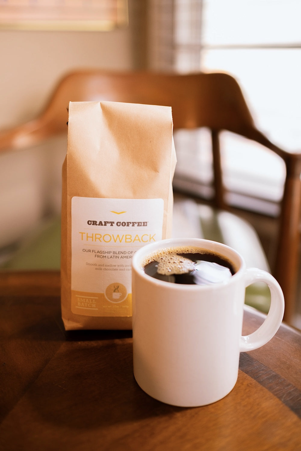 12oz bag of Craft Coffee Throwback Blend with mug of coffee on a table